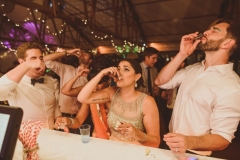the coupel and their friends have a shot at the bar in the Red Brick Barn