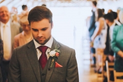 Kieran  waiting fro Amy to come down the aisle. Facing the camera and looking nervous