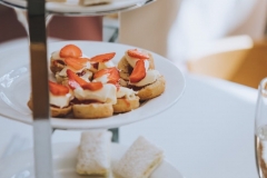 Cream teas and finger sandwiches set up on a tiered cake stand