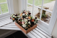 A tray of flowers sitting on a shelf